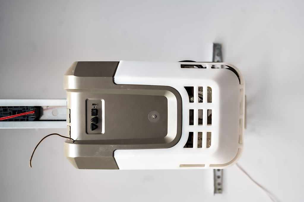 Ceiling mounted projector viewed from below showing vents and mounting bracket in a room