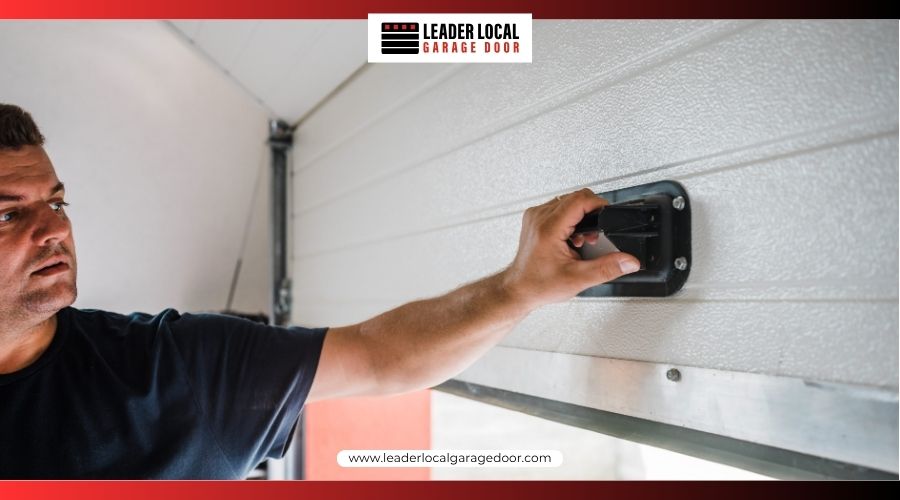 A man lifting a white sectional garage door using the manual handle